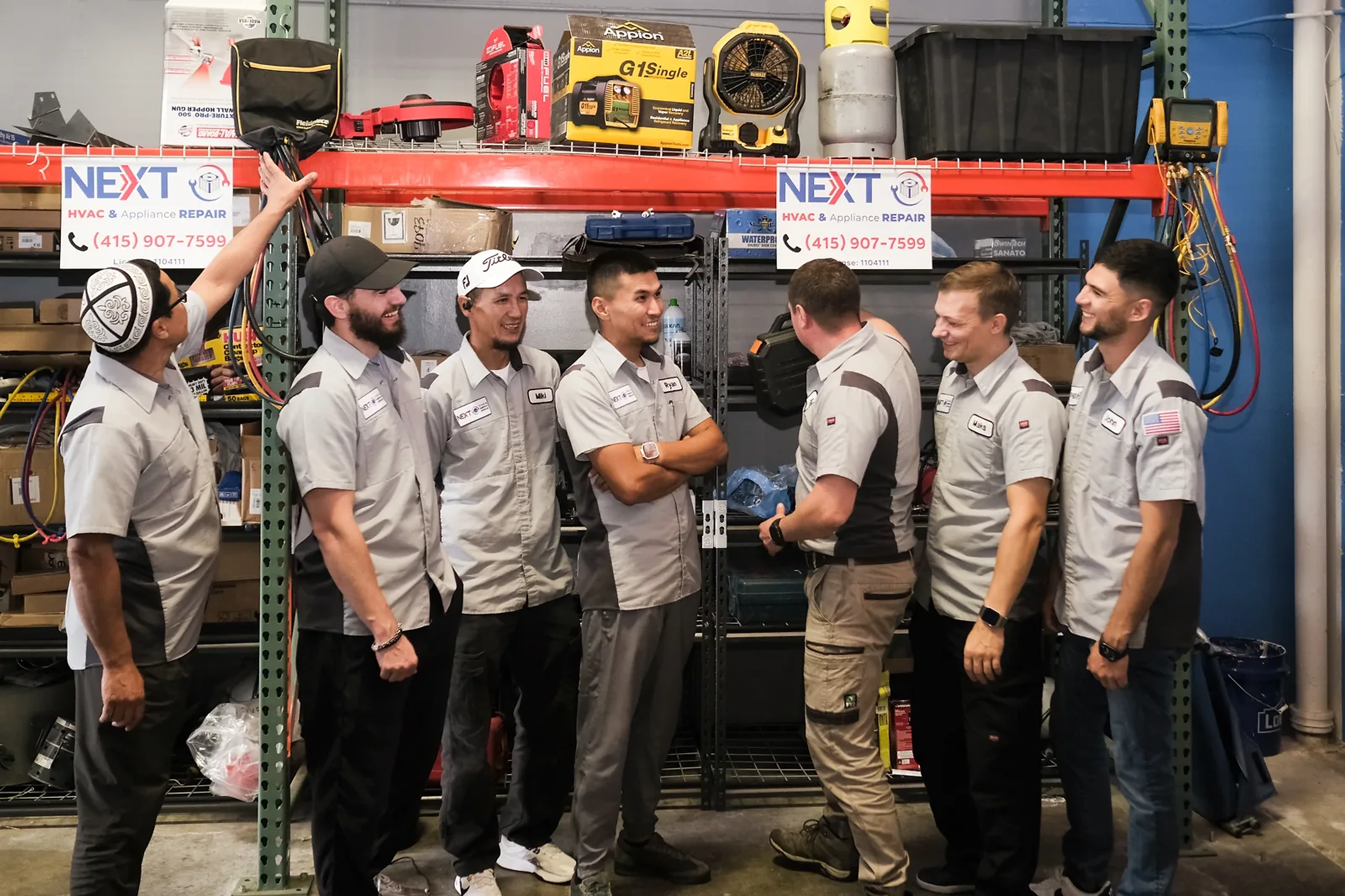 Next HVAC technicians talking beside the parts racking on the shop floor