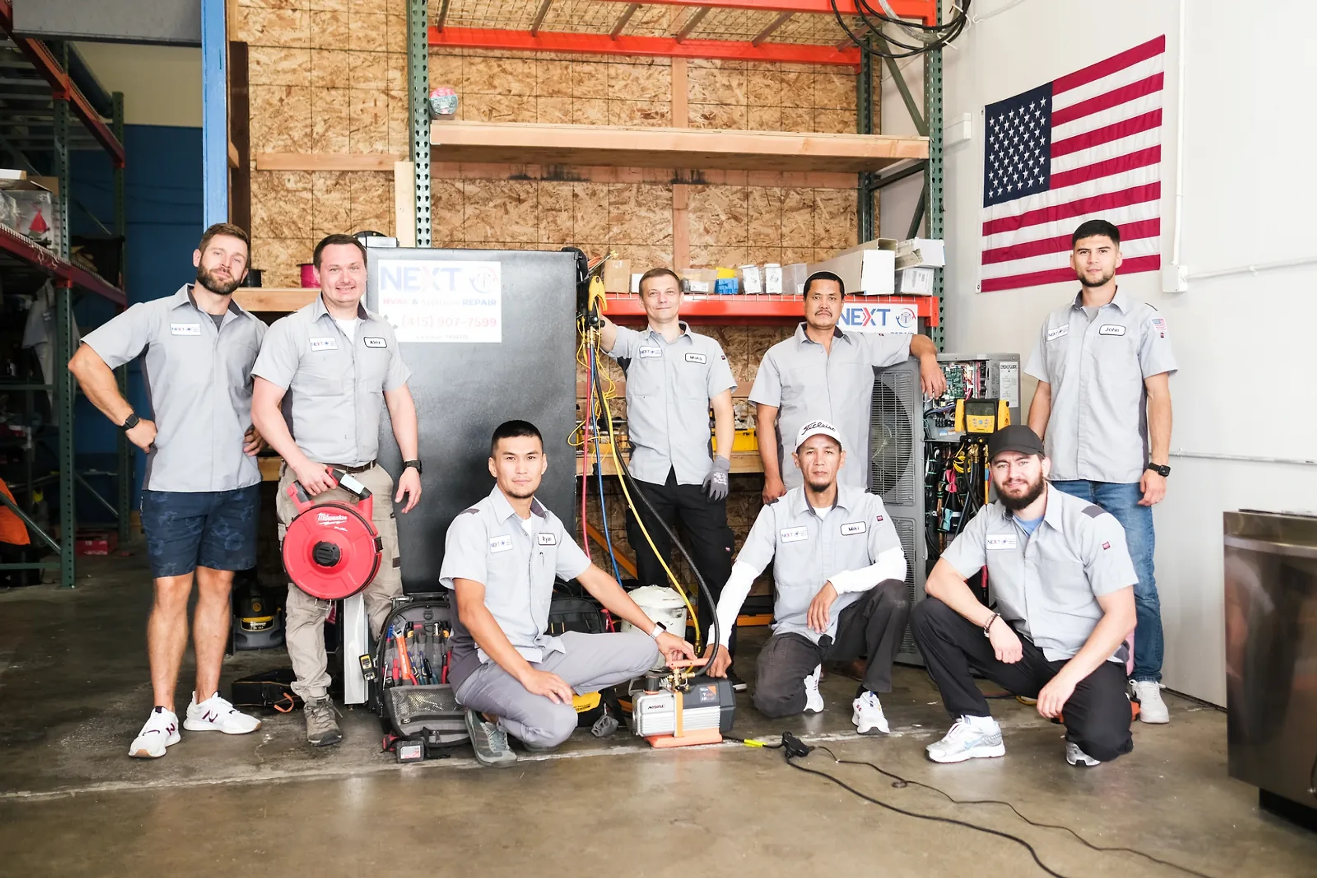 Next HVAC technicians gathered around an air handler and condenser at the company shop