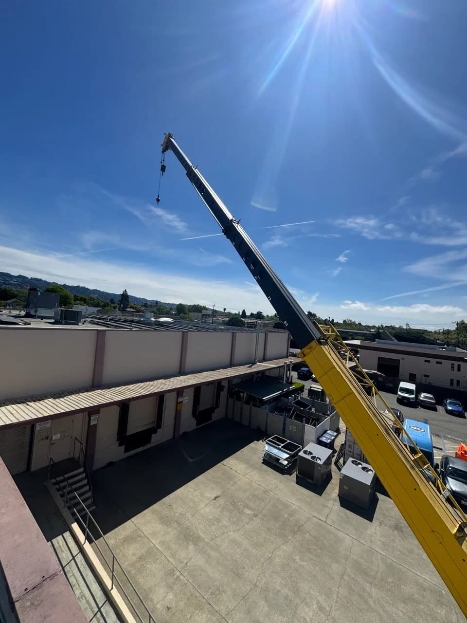 Crane boom swung over a rooftop during a unit changeout