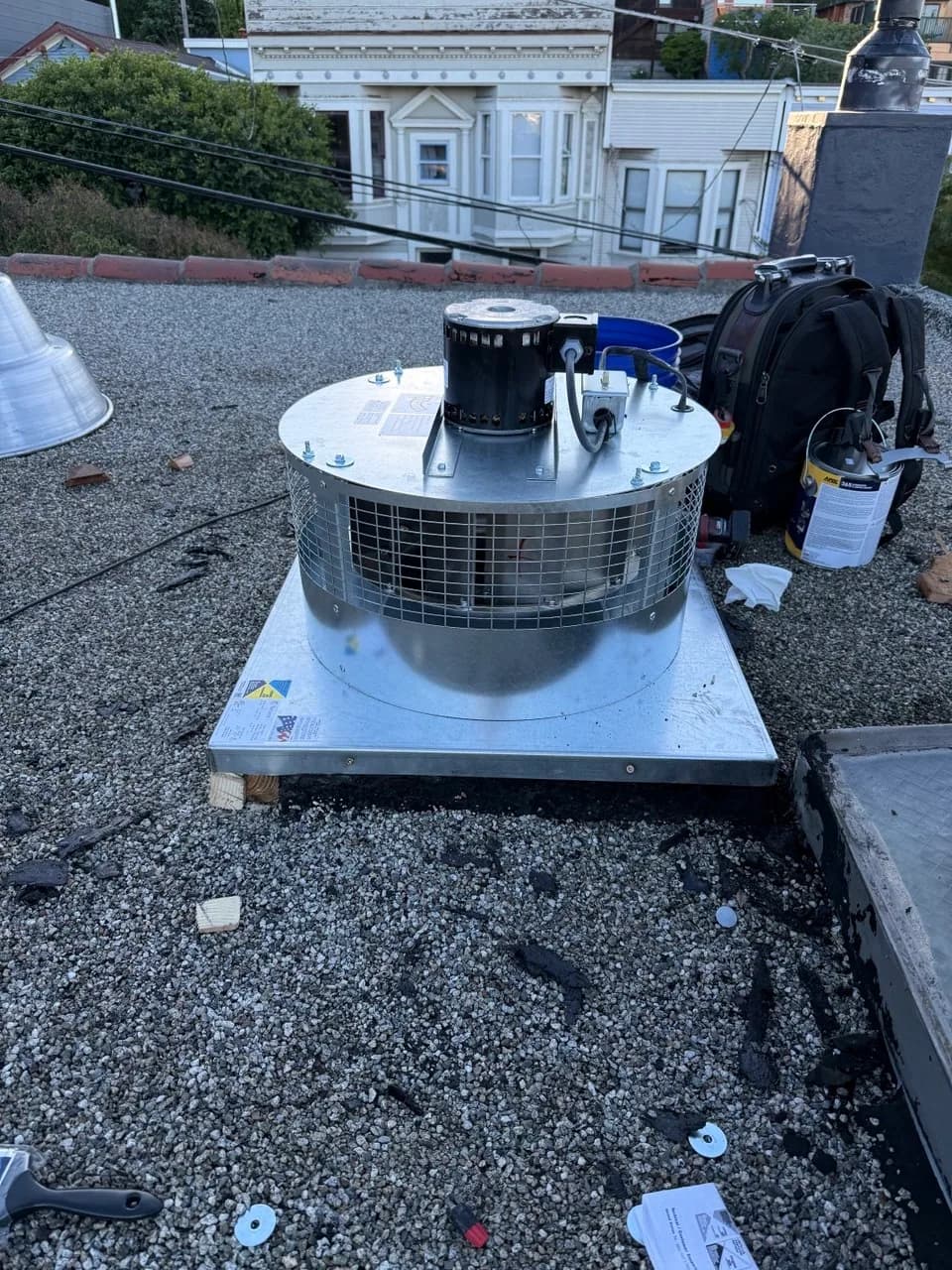 Rooftop exhaust fan assembly set back onto its curb