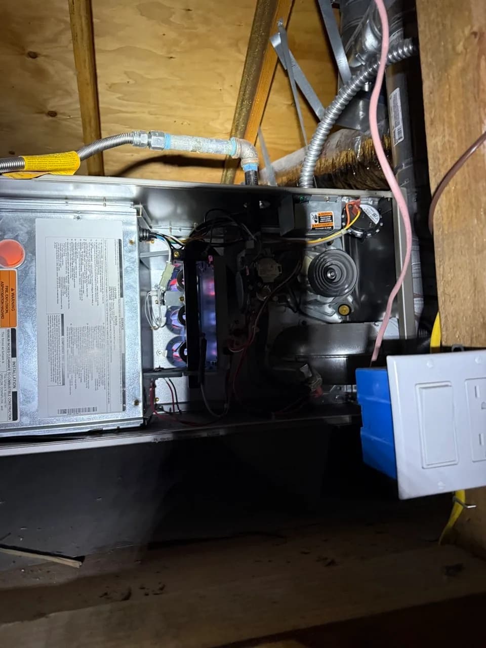 Open furnace cabinet showing wiring, control board and gas train