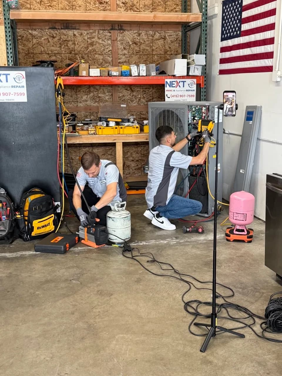 Two technicians charging heat pump units during shop start-up