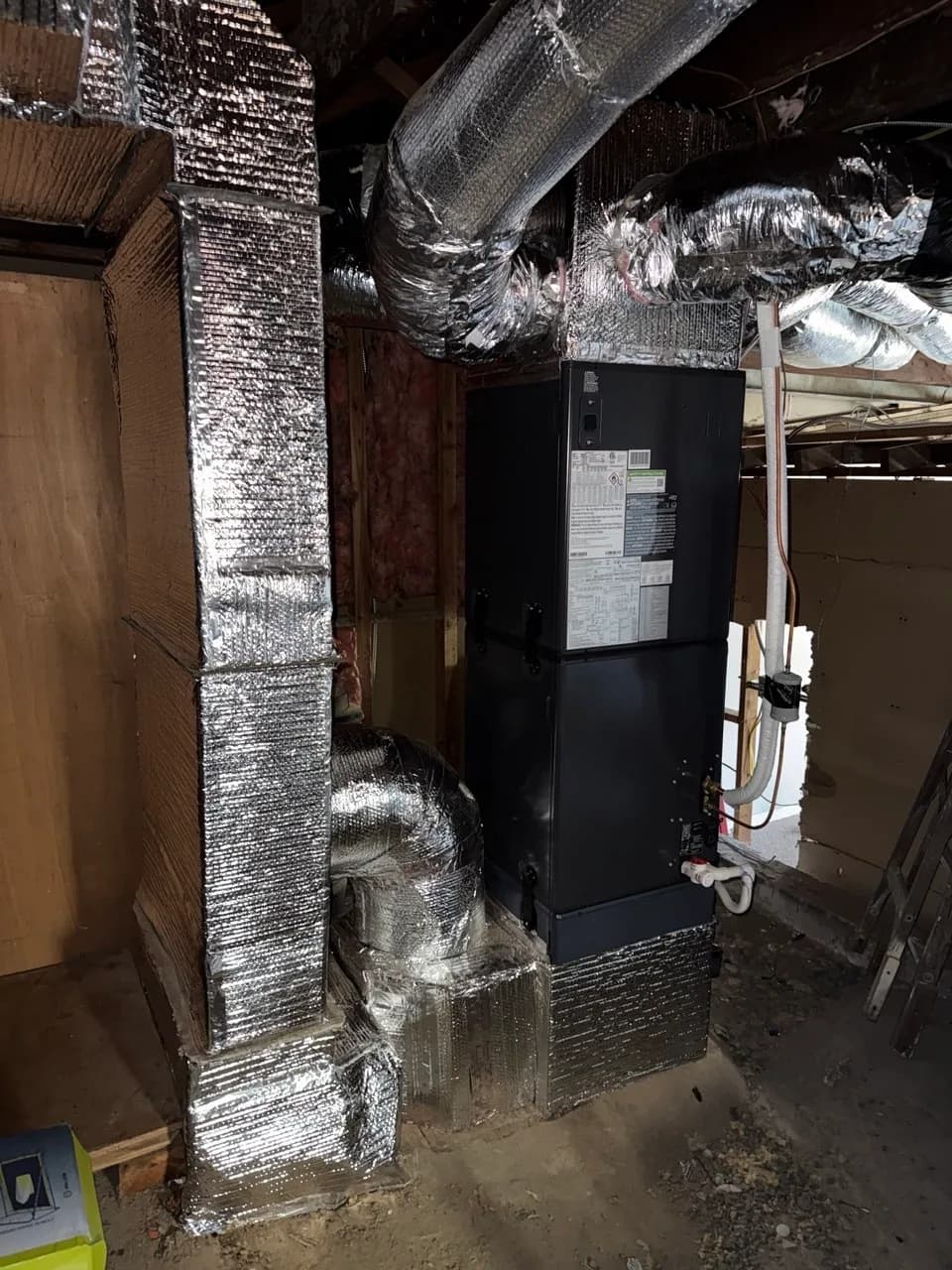 Air handler cabinet connected to insulated round ducts in a basement