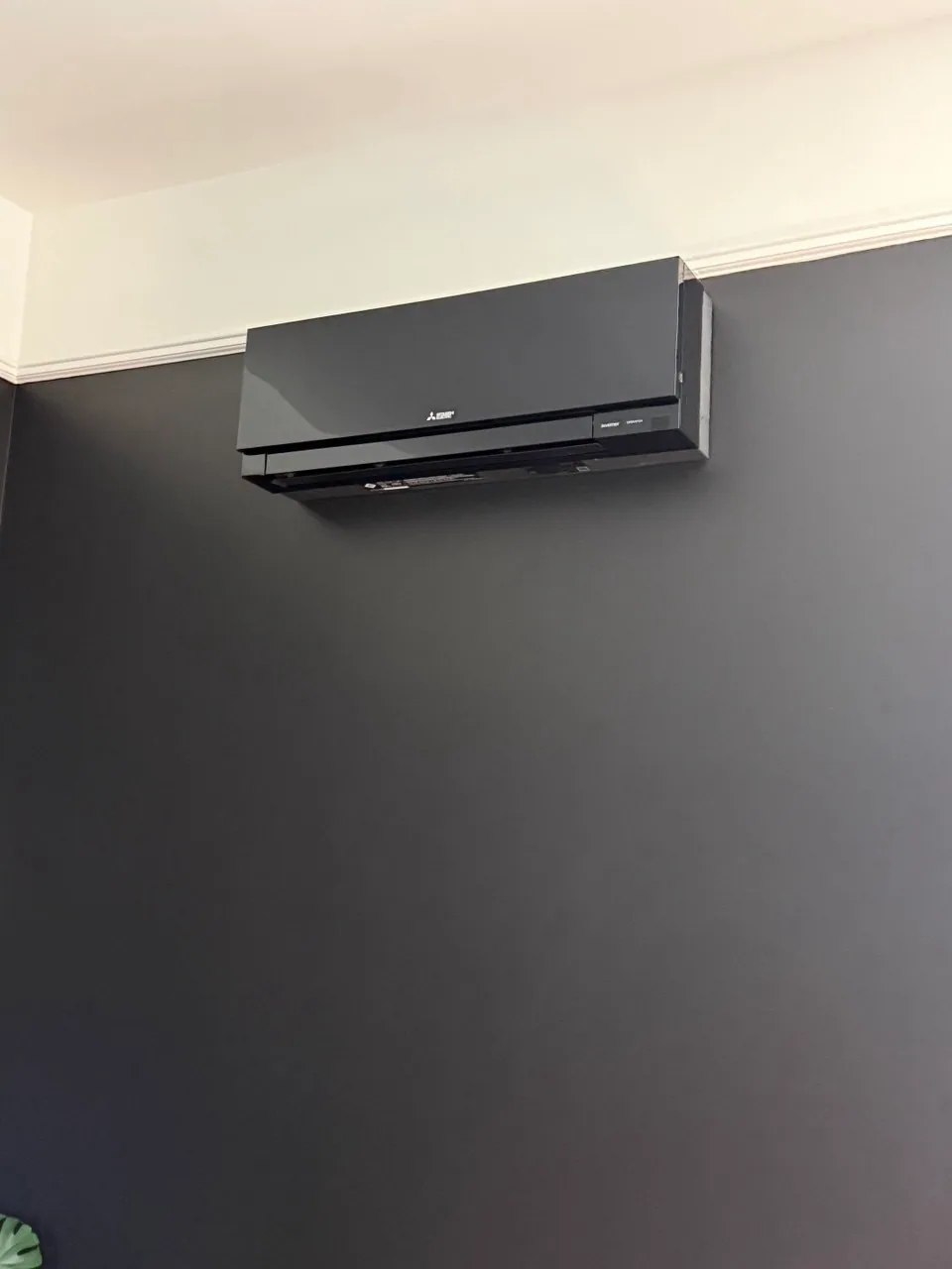Black ductless mini-split indoor head mounted on a grey feature wall