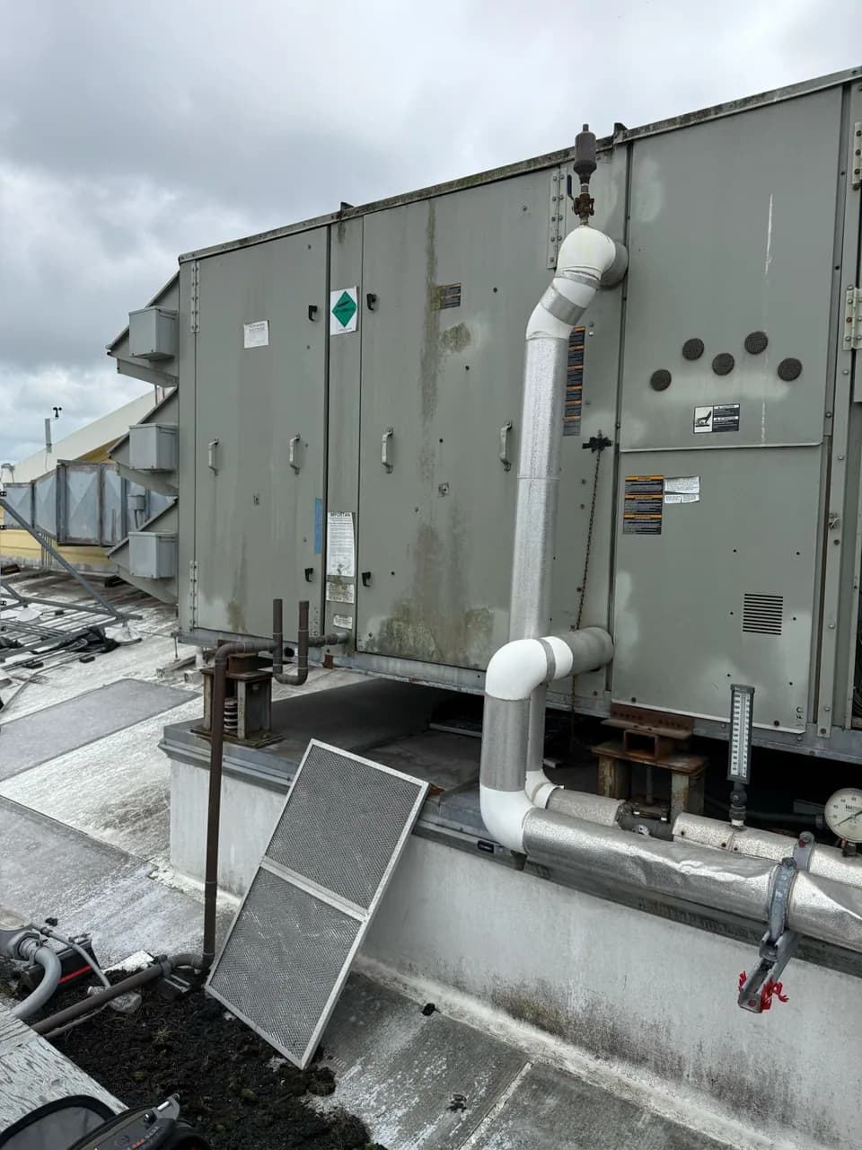 Condensate and gas piping run alongside a rooftop unit