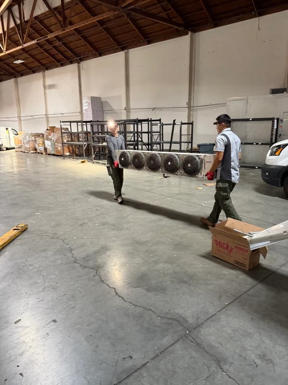 Technician walking a refrigeration line run through a warehouse